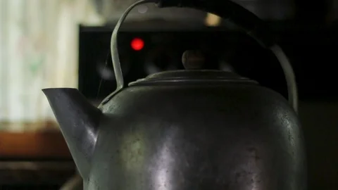 Lifting the lid off of a rustic tea kettle of boiling water in a rustic cabin Stock Footage 89503086