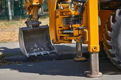 The lifting machine bulldozer stands on stops, rests on the asphalt Stock Photos