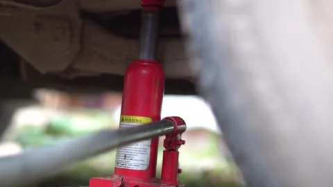 Lifting up machine with a jack close-up. Video stock 143575042