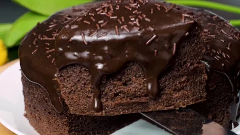 Lifting a Moist Chocolate Cake Slice with Rich Ganache Flowing Down Stock Footage 304721558