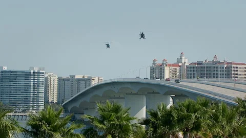 Lifting out of trees as two chopper follow police chase 動画素材 136200701
