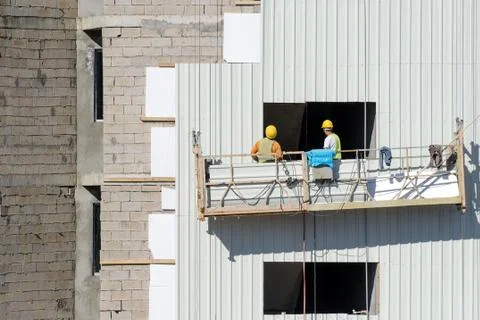 Lifting platform with builders. Stock Photos