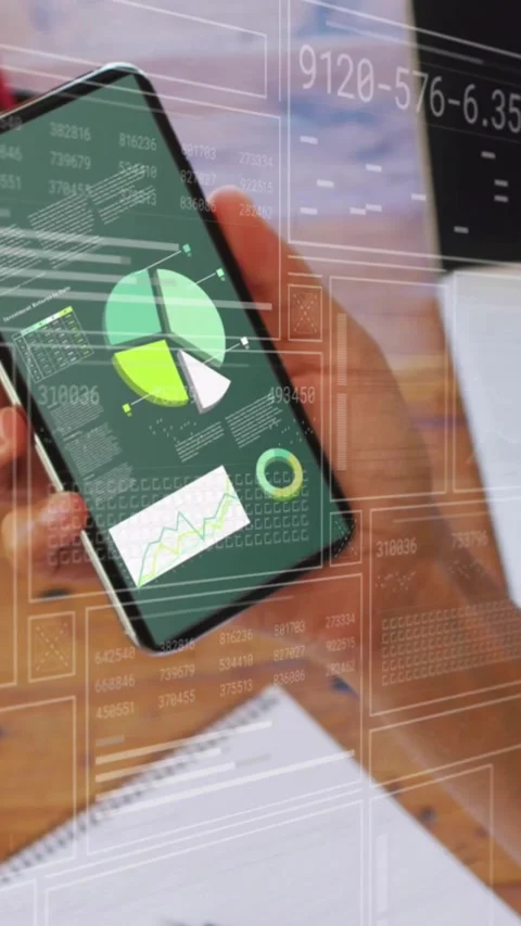 Lifting right hand rotating smartphone above desk checking green dashboard, with Video stock 330333034