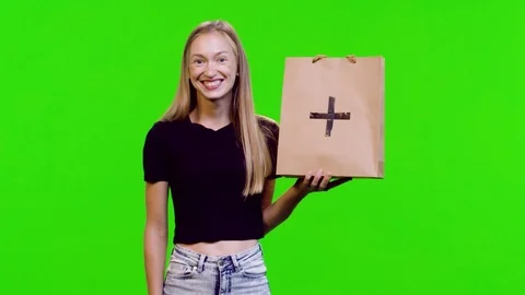 Lifting a shopping bag (with a marker) by a model over green screen. 3 takes. Stock Footage 113860994