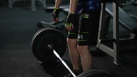 Lifts barbell from the floor 库存影片 334721160
