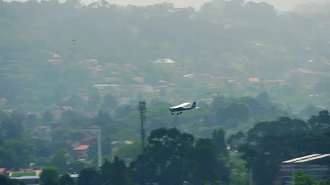 Light Aircraft Flying Low Over Tropical Hazy Landscape Stock Footage 346400344
