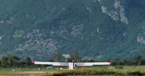 Light Aircraft Takes off with Mountains in Background Stock Footage 263680974