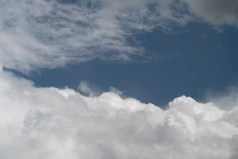 Light and airy clouds beneath blue heavens. Gentle fluffy clouds floating und Stock Photos