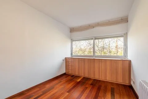 Light and compact empty room with dark wood laminate and a closet near the Photos