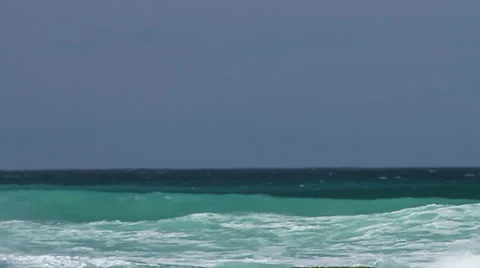 Light and dark Blue waves roll in and final one explodes onto rocks Stock Footage 32285981