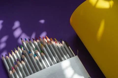 Light and shadow composition with a set of gray wooden pencils on a yellow an Stock Photos