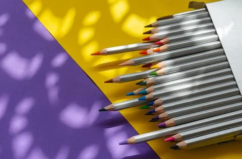 Light and shadow composition with a set of gray wooden pencils on a yellow an Stock Photos
