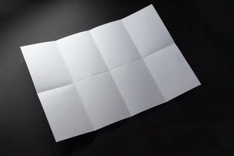 Light and shadow on creases in sheet of white paper folded into eight equal Illustrazione stock