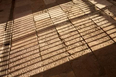 Light and shadow pattern on stone ground, bars, jail, traped Stock Photos