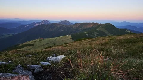 Light and shadow of the setting sun illuminate a mountain ridge in the Stock Footage 251855771