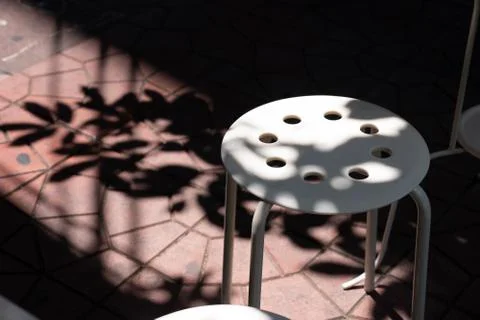 Light and shadow on white plastic stool outside  Stock Photos