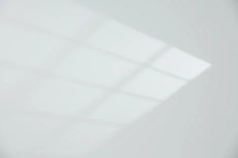 Light and shadow from window on white wall, space for text Stock Photos