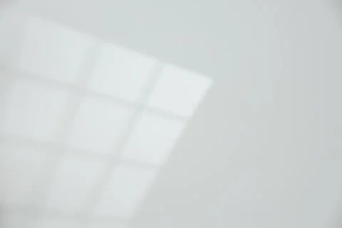 Light and shadow from window on white wall, space for text Stock Photos