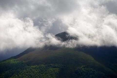 Light and shadows play between clouds and glades in the mountains Stock Photos