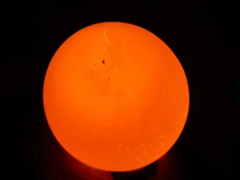 The light is on the back of the egg and the egg is bright yellow. Stock Photos