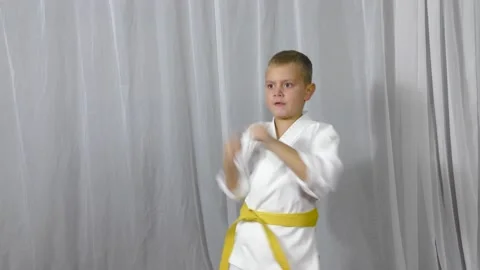 On a light background, an athlete and with a yellow belt hits punches Stock Footage 162622382
