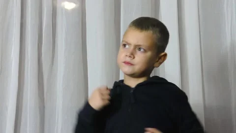 On a light background, an athlete in a black jacket trains punches Stock Footage 162622307