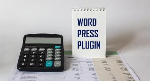 On a light background, a calculator with documents and a notepad with the tex Stock Photos