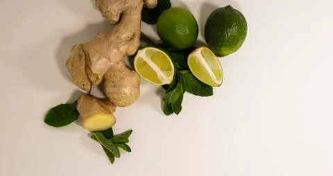 Light background with healthy tea supplements.Ginger root, mint, lime.Copy space Stock Photos