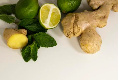 Light background with healthy tea supplements.Ginger root, mint, lime.Copy space Stock Photos