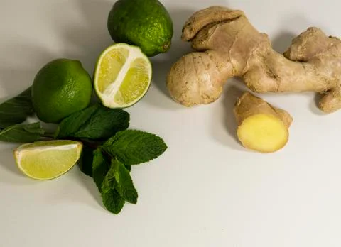 Light background with healthy tea supplements.Ginger root, mint, lime.Copy space Stock Photos