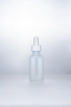 Light backlit face serum in matte bottle Stock Photos