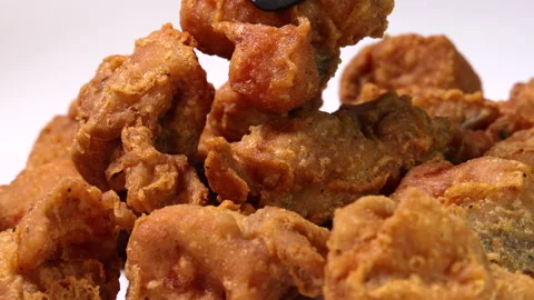 Light battered deep fried chicken variety mix pieces pile flaky meat on white ba Stock-Footage 155422113