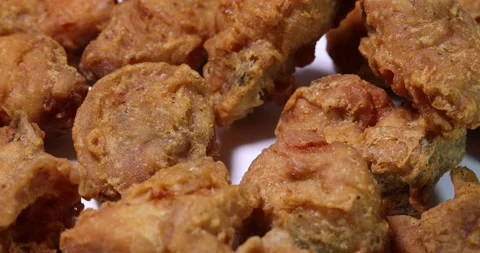 Light battered deep fried chicken variety mix pieces pile flaky meat on white Stock Footage 155422999