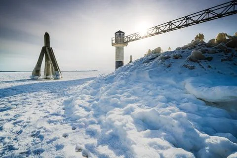 Light beacon or lighthouse in winter landscape at a dutch lake Stock Photos