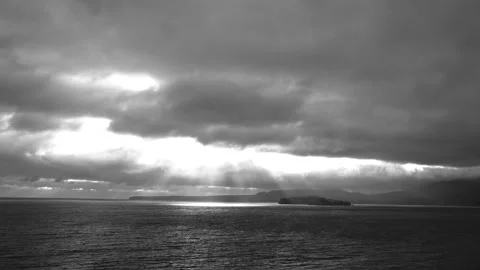 Light Beaming Through Clouds Onto The Ocean With Landscape - Black and Whi Stock Footage 255318040