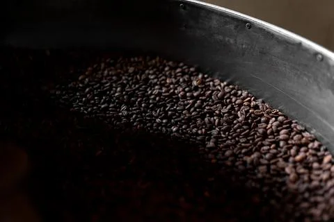 A light bean is lighting up some coffee grains inside of the roaster machine Stock Photos