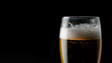 Light beer pouring in glass. With bubbles and foam. On the left edge of the Stock Footage 136384764