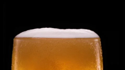 Light beer pouring in glass with bubbles and foam on black background Stock Footage 155906230