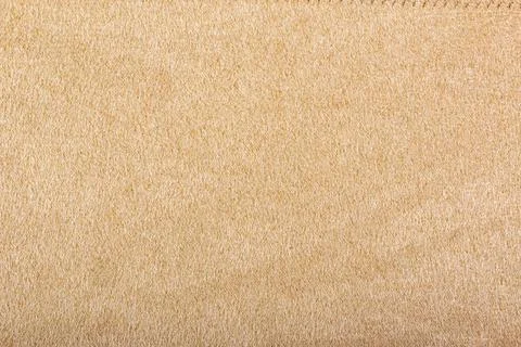 Light beige matte background of suede fabric, closeup. Beige suede soft leather Stock Photos