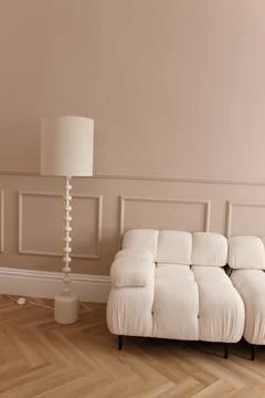 A light beige sofa and a table lamp as part of the interior Stock Photos