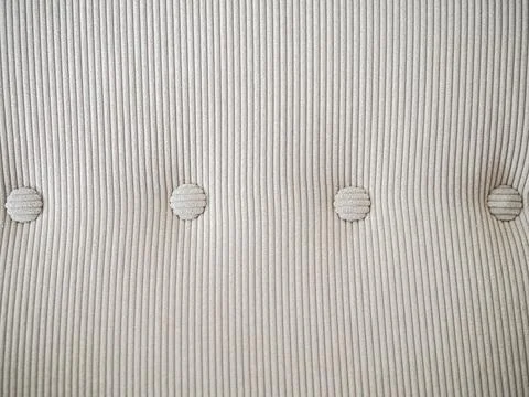 Light beige velour textile pattern with buttons. Furniture sofa cover. Stock Photos