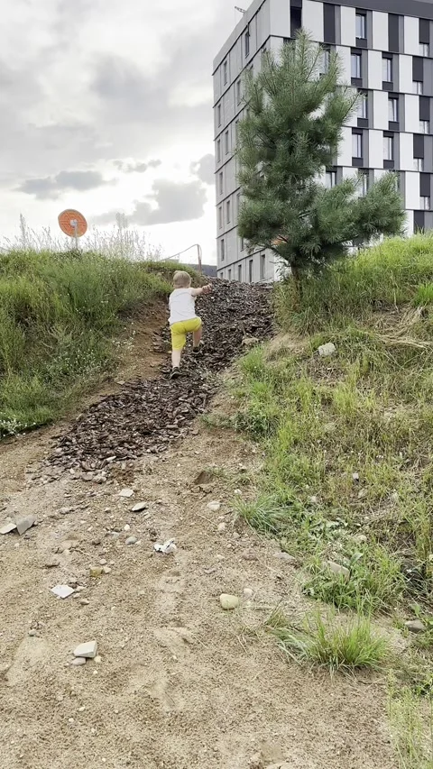 Light-blond child climbs up the hill Stock Footage 280437317