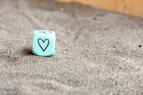 Light blu plastic cube with heart and weather symbols on it's sides. Funny Stock Photos