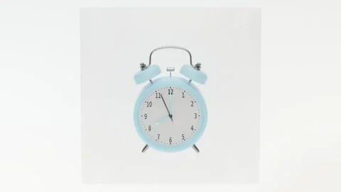 A light blue alarm clock with its hands showing 7:55 in a vacuum packing on.. Stock Footage 332146204