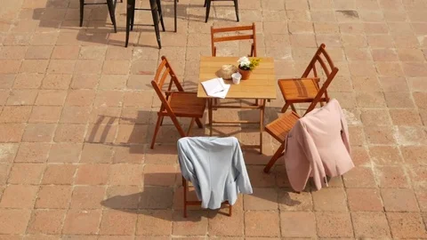  Light blue and light pink jackets on the chairs, in the wind.  Video stock 85252117