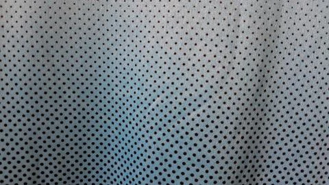 Light blue athletic fabric featuring a repeating pattern of dark dots Stock Photos