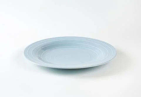 Light blue ceramic dinner plate on plain background Stock Photos