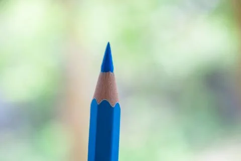 Light blue colored one single wood pencil crayon in front of a blurry backgro Stock Photos
