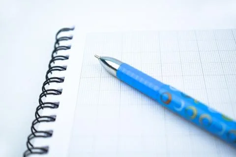 A light blue colored pen placed on top of a simple open white paper diary Stock Photos