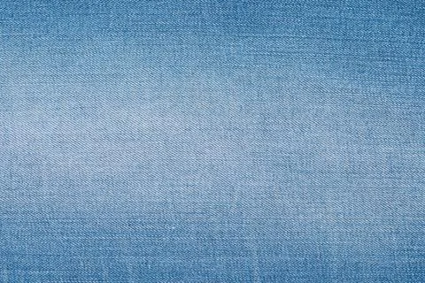 Light blue denim fabric texture. Faded jeans material with classic diagonal t Stock Photos